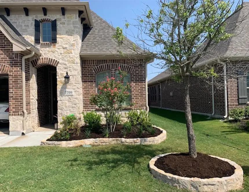 Stone landscape borders and planted front beds completed by Landmark Landscapes